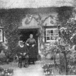 Photo of old couple sitting outside Bay Tree Cottage Breinton Common early 1900s