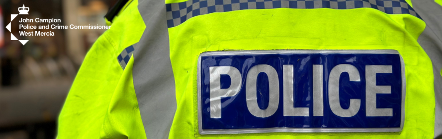 A hi-viz coat with police written on the back with the logo of John Campion the police and crime commissioner for West Mercia Police top left